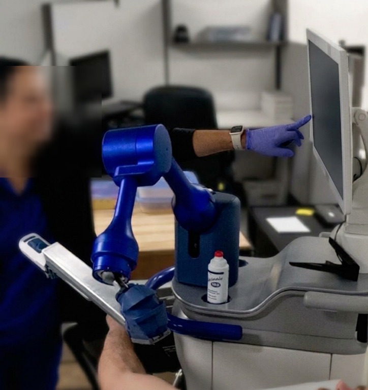 Usability testing photo showing a second operator reaching to the touchscreen, face blurred